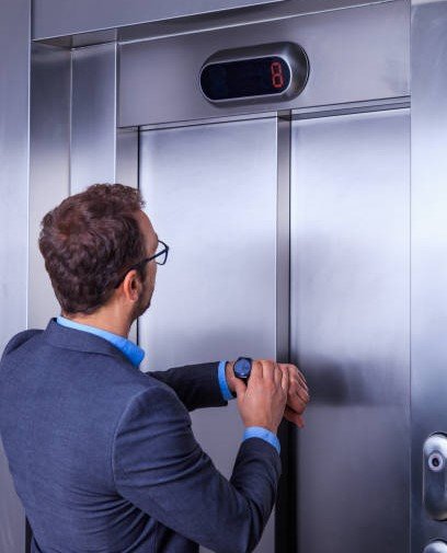 Young professional checking time in front of the elevator